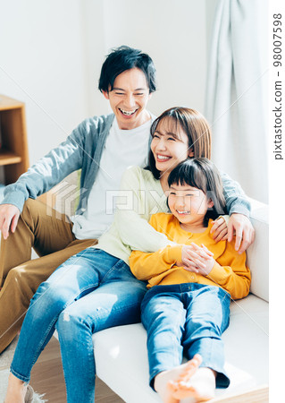 一個在客廳裡放鬆的年輕家庭 98007598