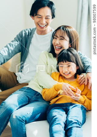一個在客廳裡放鬆的年輕家庭 98007599