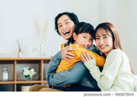 一個在客廳裡放鬆的年輕家庭 98007604