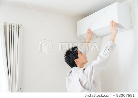 Repairman checking broken air conditioner 98007691