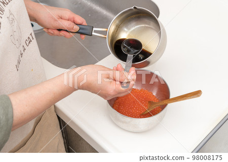 [將生三文魚子與自製醬汁混合製成醬油醃三文魚子] 98008175