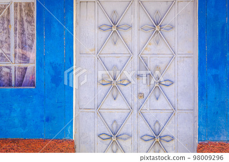 Rustic old metal door with textured adobe wall facade in Cusco, Peru Rustic old metal door with textured adobe wall facade in Cusco, Peru 98009296