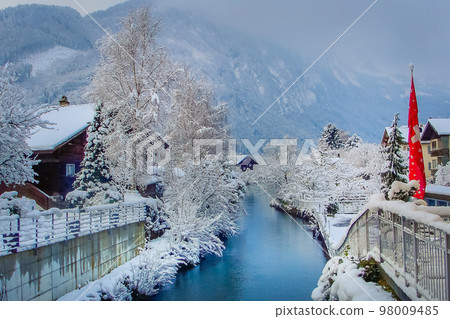 Interlaken landscape after snow in winter with river reflection, Swiss alps 98009485