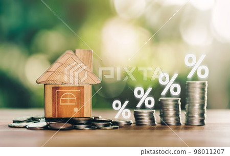 House and coins place on the wood table is ladder with white illustration shows decreasing of interest rates. House and coins place on the wood table is ladder with white illustration shows decreasing of interest rates. 98011207