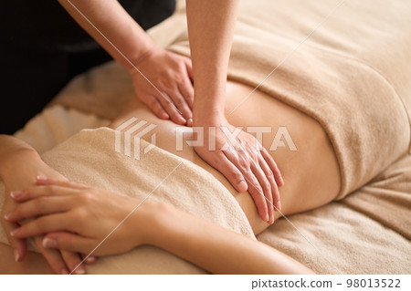 A woman receiving a belly massage at a beauty salon 98013522