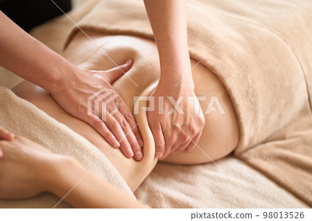 A woman receiving a belly massage at a beauty salon A woman receiving a belly massage at a beauty salon 98013526