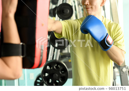 Men punching and trainer with mitts Men punching and trainer with mitts 98013751