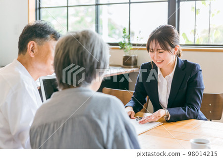A woman who is a judicial scrivener, tax accountant, social worker, and social worker explaining the plan to an elderly couple A woman who is a judicial scrivener, tax accountant, social worker, and social worker explaining the plan to an elderly couple 98014215