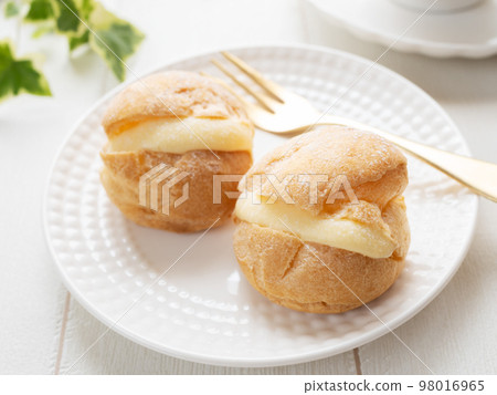 two cream puffs on a plate two cream puffs on a plate 98016965