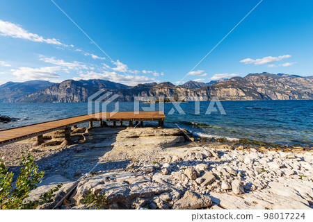Beach and Wooden Pier of Lake Garda - Malcesine Village Veneto Italy Beach and Wooden Pier of Lake Garda - Malcesine Village Veneto Italy 98017224