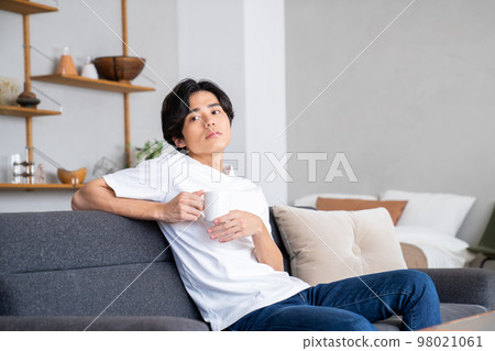 Young man relaxing in the living room Young man relaxing in the living room 98021061