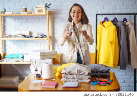 Small business owner, entrepreneur, seller using tablet checking ecommerce clothing store orders. Small business owner, entrepreneur, seller using tablet checking ecommerce clothing store orders. 98021146
