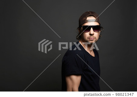Brutal Handsome Man in Hat and sunglasses. Serious Boy Brutal Handsome Man in Hat and sunglasses. Serious Boy 98021347