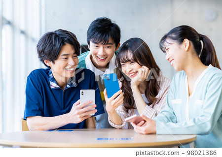 Male and female college students looking at smartphones 98021386