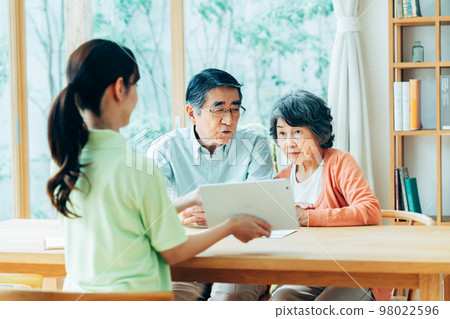 Care manager explaining to senior couple 98022596