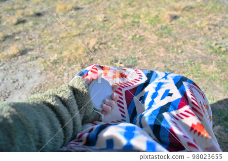 由於冬令營天氣寒冷，一名年輕女子用暖手器（可充電暖身器）暖手 98023655