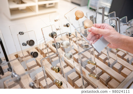 Male hand choosing cabinet door knob in furniture store Male hand choosing cabinet door knob in furniture store 98024111