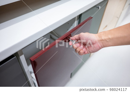 Male hand opening drawer on white cabinet Male hand opening drawer on white cabinet 98024117