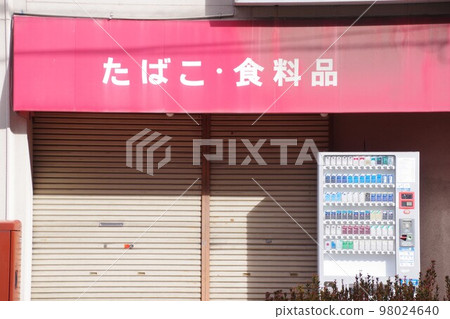 The storefront of a tobacco shop with shutters down 98024640
