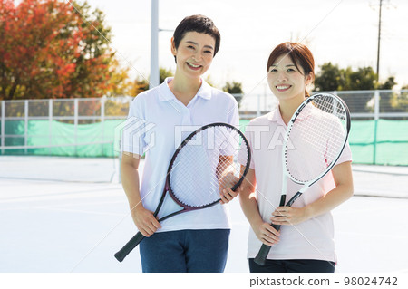 A woman enjoying tennis A woman enjoying tennis 98024742