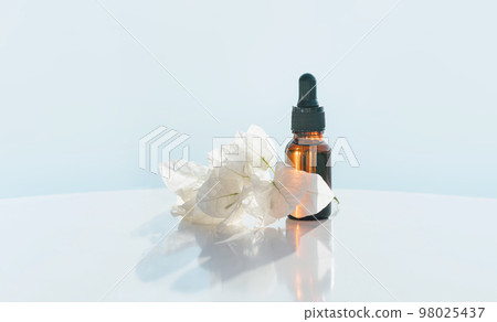 Natural medicine or essential aroma oil or beauty essence amber glass vial with dropper with white flowers and airy blue background. Face and body spa serum care concept banner Natural medicine or essential aroma oil or beauty essence amber glass vial with dropper with white flowers and airy blue background. Face and body spa serum care concept banner 98025437
