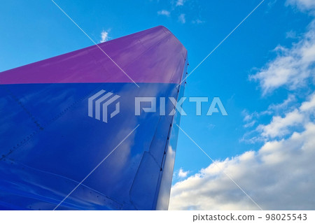 The wing of the aircraft against the background of the blue sky. Safe transport. 98025543