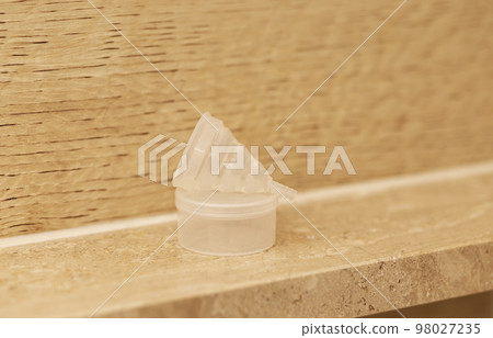 Silicone menstrual period soft cup on marble shelf with container in bathroom. Reusable zero waste concept during menstruation. Female's health, alternative intimate hygiene. Horizontal Silicone menstrual period soft cup on marble shelf with container in bathroom. Reusable zero waste concept during menstruation. Female's health, alternative intimate hygiene. Horizontal 98027235