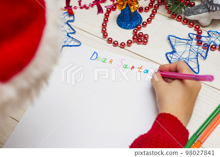 Little boy in Santa hat writes letter to Santa Claus Little boy in Santa hat writes letter to Santa Claus 98027841