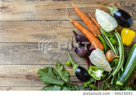 Organic vegetables for healthy cooking background. Fall harvest. The concept of vegan or diet food. Various vegetables on a rustic kitchen table. View from above. Organic vegetables for healthy cooking background. Fall harvest. The concept of vegan or diet food. Various vegetables on a rustic kitchen table. View from above. 98028891