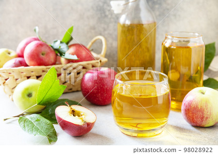 Autumn vitamin drink juice apple. Apple juice in a glass and fresh apples on a stone tabetop. 98028922