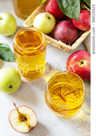 Apple juice in a glass and fresh apples on a stone tabetop. Autumn vitamin drink juice apple. Apple juice in a glass and fresh apples on a stone tabetop. Autumn vitamin drink juice apple. 98028928