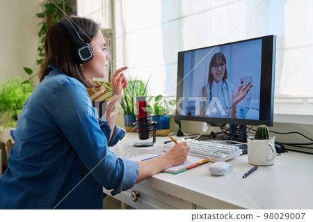 Young woman having video conference with doctor 98029007