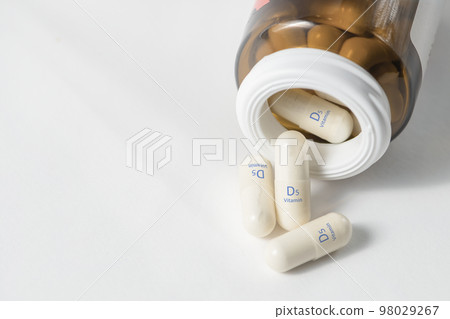 Vitamin D5. Sitocalciferol capsules are essential for bone growth. White capsules of vitamin D5 or sitocalciferol are scattered on the table with copy space. 98029267