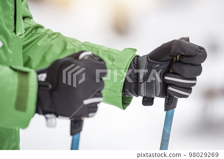 Nordic walking in winter. Sports activities in the winter on the snow. A man is engaged in Nordic walking with special sticks in the winter nature outdoors. Place for copy space. 98029269