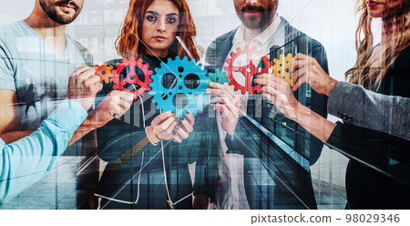 Teamwork of businesspeople work together and combine pieces of gears as partnership and integration 98029346