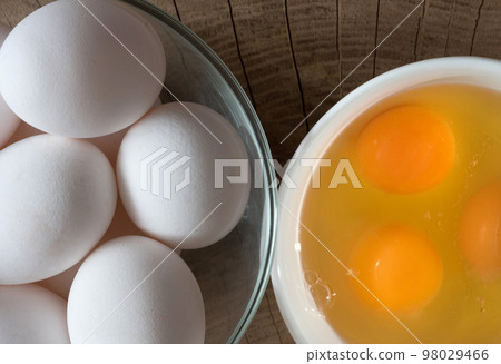 Chicken eggs, Yolk in a ceramic dish on a wooden background, top view Chicken eggs, Yolk in a ceramic dish on a wooden background, top view 98029466