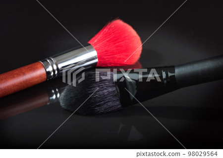 Black and red brush for a make-up on a black background. close up 98029564