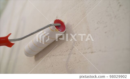 Wall paint roller. Roller Brush Painting, Worker painting on roller brush for protection Wall paint roller. Roller Brush Painting, Worker painting on roller brush for protection 98029902