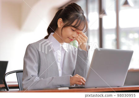 案頭工作_眼睛疲倦把手放在太陽穴上的女人 98030955