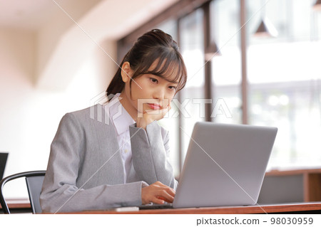 Desk work_Woman looking at PC with embarrassed face with cheeks_1 Desk work_Woman looking at PC with embarrassed face with cheeks_1 98030959