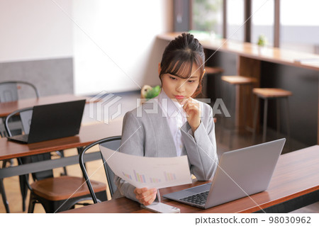 Desk work _ woman thinking with a graph in hand _ 2 98030962