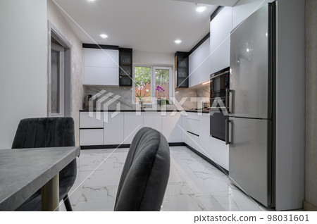 New large modern well designed white kitchen and dining room in studio flat interior New large modern well designed white kitchen and dining room in studio flat interior 98031601