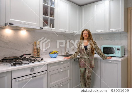 Portrait of young cute housewife in the kitchen interior 98031609