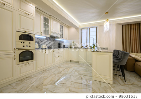 Cream-colored classic kitchen with island serving as dining area in studio apartment Cream-colored classic kitchen with island serving as dining area in studio apartment 98031615