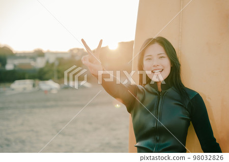 A young woman who enjoys surfing 98032826
