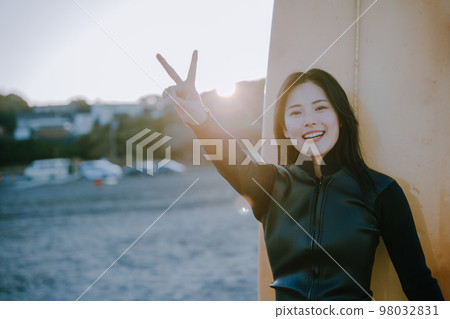 A young woman who enjoys surfing 98032831