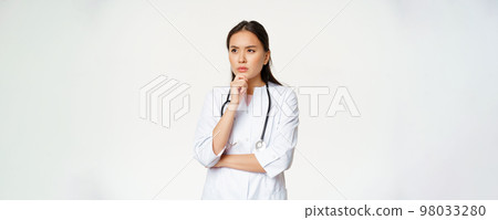 Image of serious doctor, female healthcare worker thinking, looking aside with concerned, frowning face expression, white background 98033280