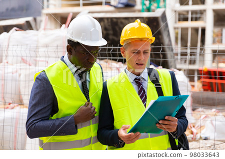 Builders talking about work outdoors 98033643