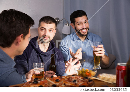 Three men talking and laughing at home Three men talking and laughing at home 98033685