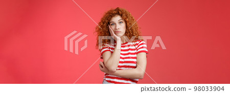 Playful redhead gorgeous girl feel sad lacking energizing party lean palm look indifferent express boredom lonely feelings attend boring meeting standing upset reluctant red background 98033904